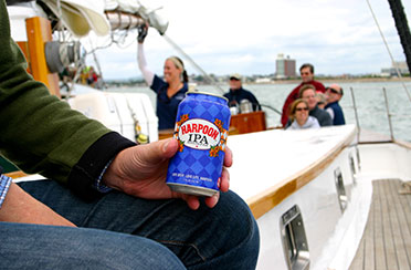 Close up of customer holding a Harpoon Beer aboard the Schooner Adirondack III