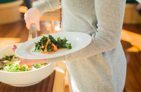 Close up photo of a woman putting salad on her plate for a Boston Harbor Brunch Cruise on Yacht Northern LIghts