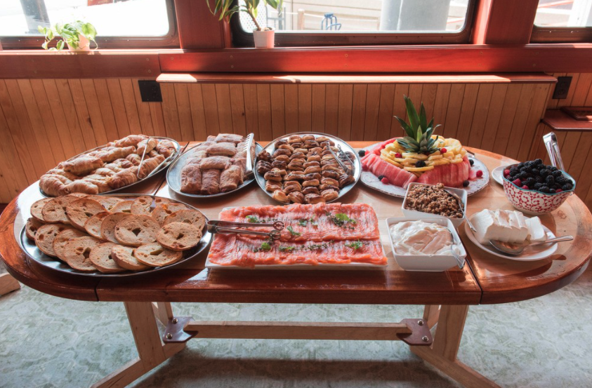A wooden table with a lot of food on it.