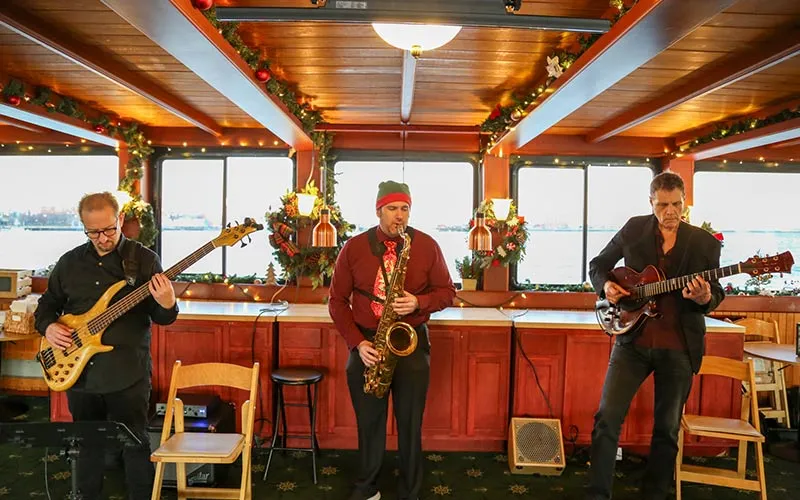 a holiday festive band playing instruments, inside of a holiday decorated motor yacht