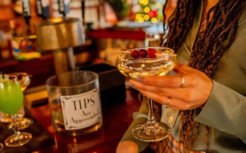 closeup of a martini being held by a woman, in front of the bar area aboard a motor yacht