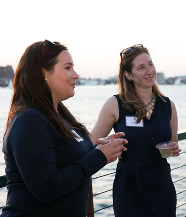 Boston_Meeting-Conference-Capacities two women, holding drinks, chatting and smiling while aboard a motor yacht