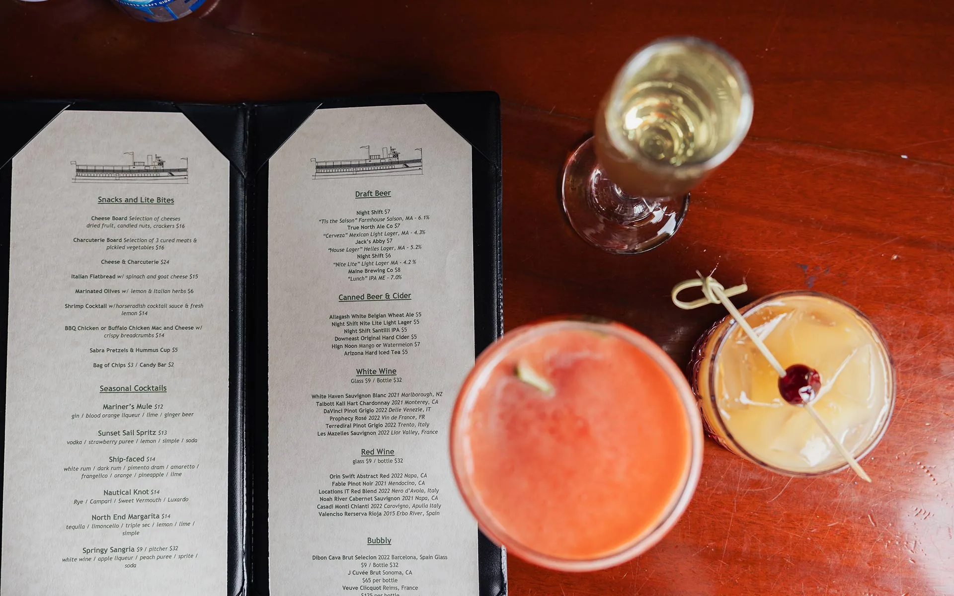 closeup of drinks on a table, with a food/drink menu next to them