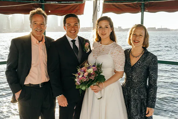 a man and a woman that was just married, posing for a photo with their relatives on a motor yacht