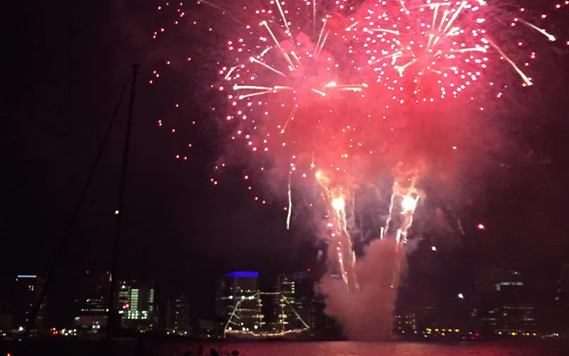 fireworks being shot off into the night sky above the Boston harbor