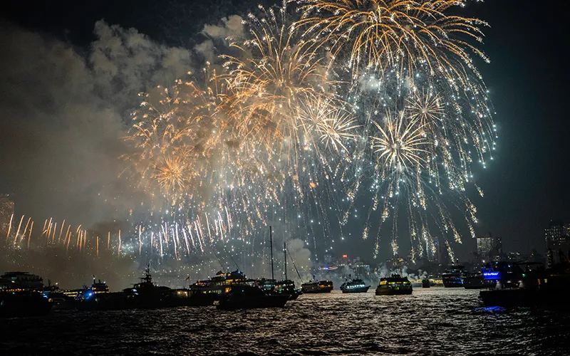 Boats in the water with fireworks in the sky