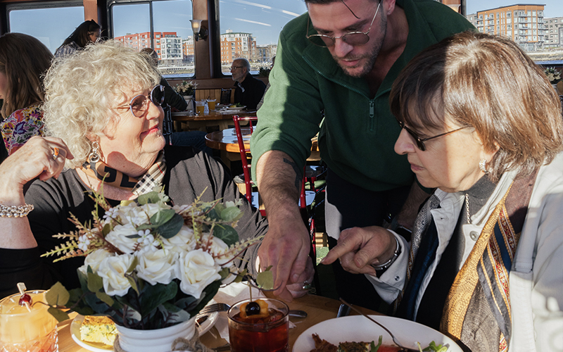 Crew Member serving customers aboard the Boston Brunch Cruise