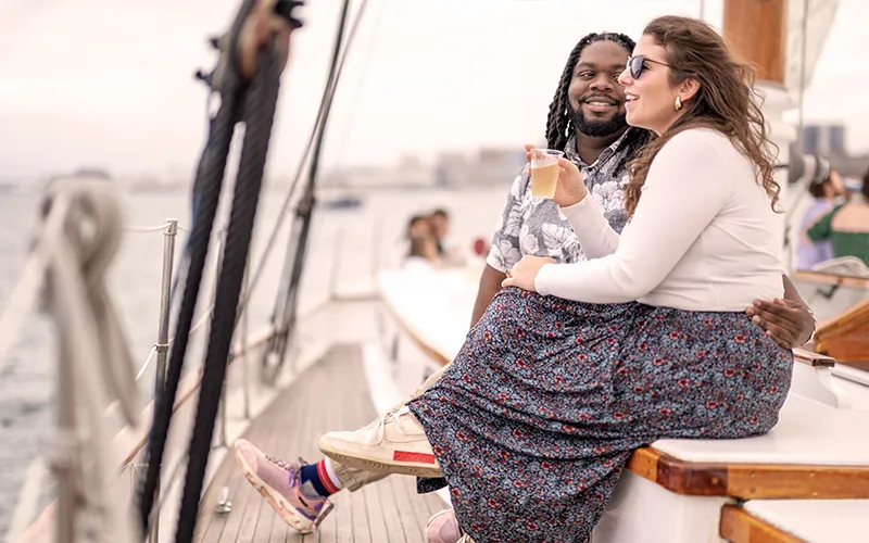 Guests enjoying a sunset sail aboard schooner Adirondack III in Boston Harbor