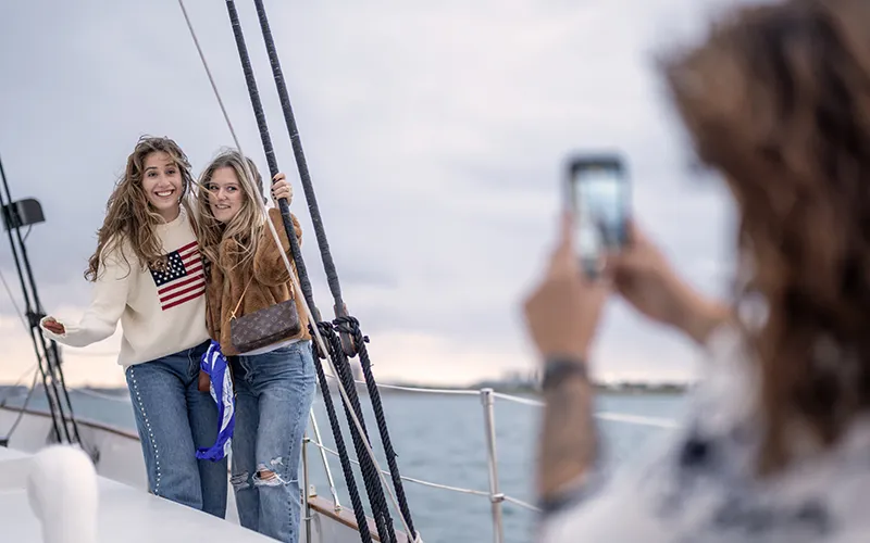 Two friends getting their picture taken on the deck of Schooner Adirondack III in Boston Harbor