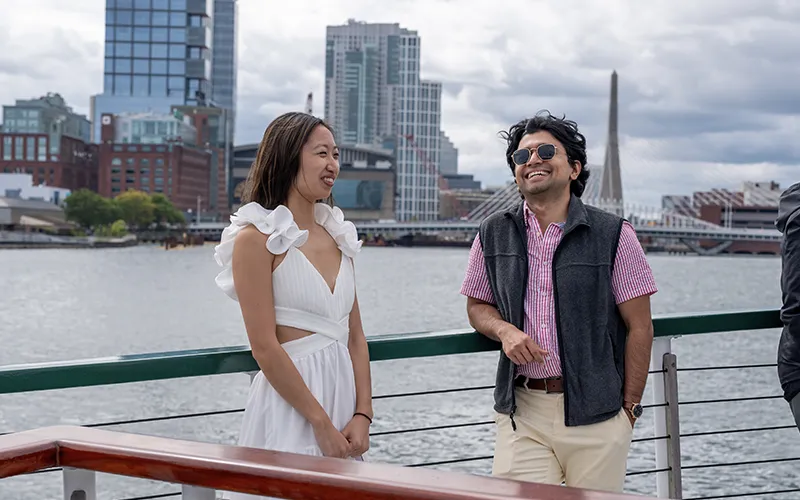 Guests on the bow of yacht Northern Lights with the Boston Skyline in the background for a sightseeing cruise