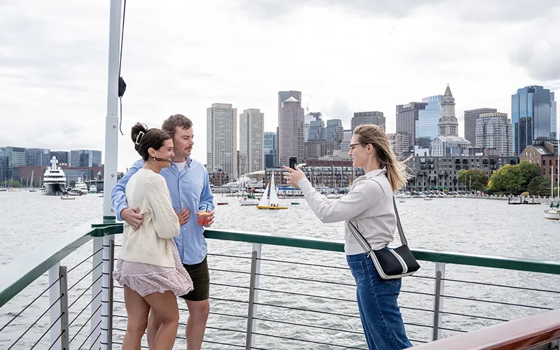 A couple getting their photo taken on the bow of Yacht Northern lights for a sightseeing cruise