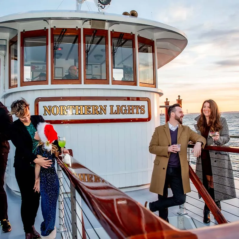 several people all on the upper deck of the motor yacht Northern Lights, cruising along the water