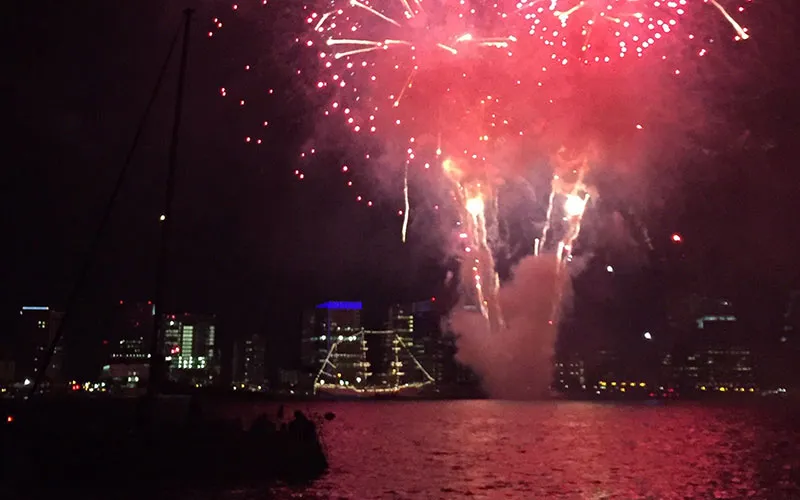 fireworks being shot off into the night sky above the Boston harbor