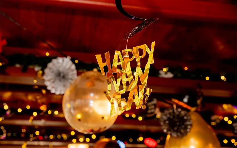 Boston_New-Years-Eve-Fireworks-Music-Slider-1 closeup of a banner with cutout words that read "happy near year!" hanging from the ceiling of a motor yacht