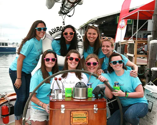 a group of women all wearing the same attire for a bachelorette party aboard a sailboat