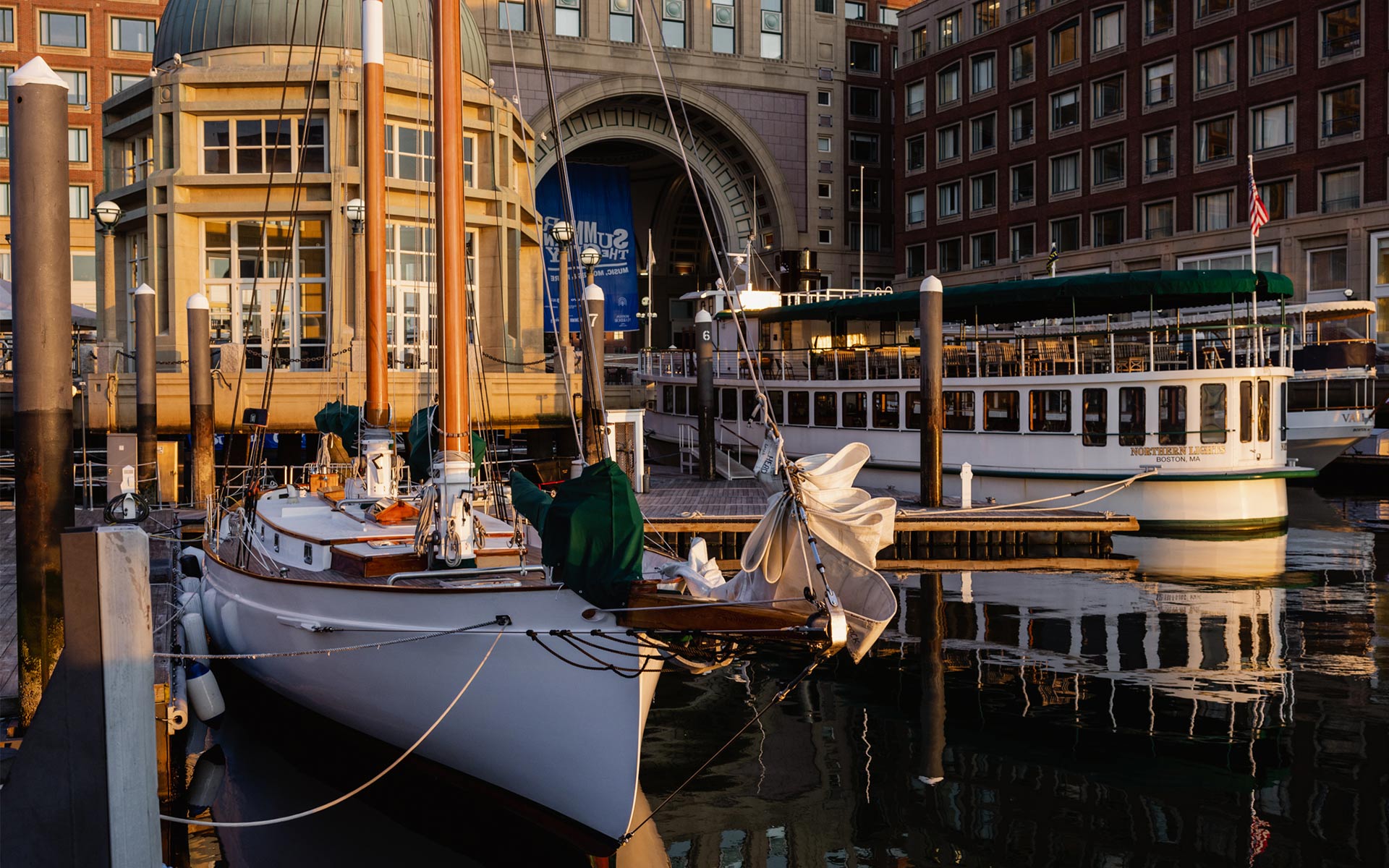the yacht Northern Lights and Schooner Adirondack docked at a pier in Boston