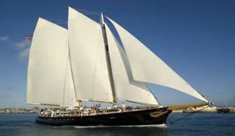 the Schooner America 2.0 sailboat cruising down the river