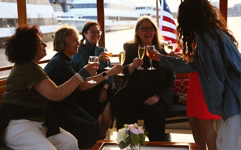 Group of friends enjoying Champagne on a sunset cruise aboard the yacht Patriot