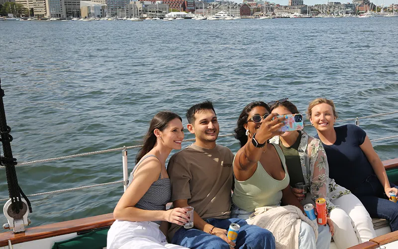 Group of friends taking a selfie on the Schooner Adirondack II for a day sailing trip in Boston Harbor