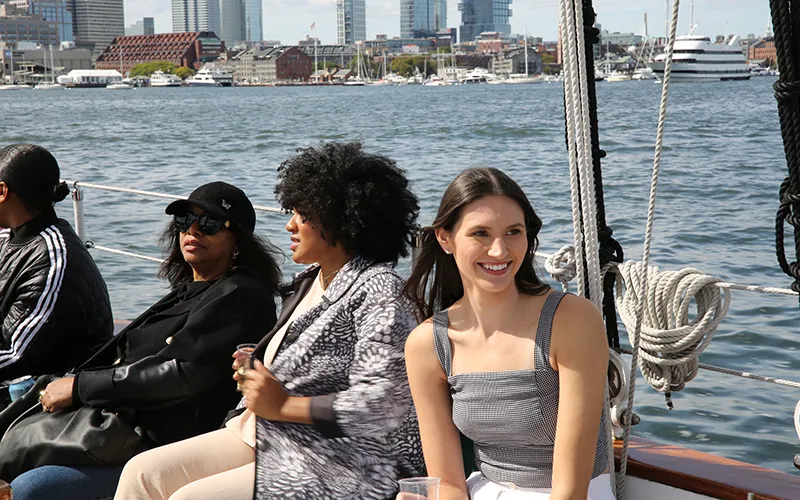 Guests aboard Schooner Adirondack II in Boston Harbor with the city skyline in the background