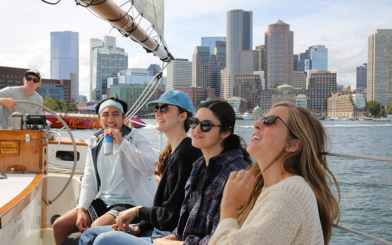 Guests aboard Schooner Adirondack II in Boston Harbor with the city skyline in the background