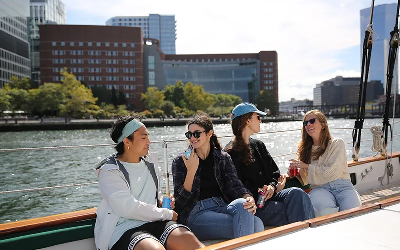 Group. of Friends on the Schooner Adirondack II sailing in Boston Harbor with the skyline in the background