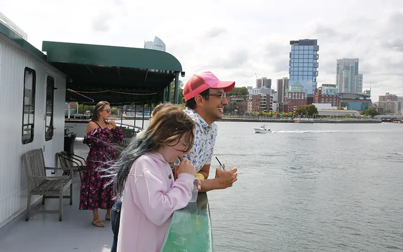 Man and his daughter enjoying a sightseeing boat ride on yacht Northern Lights in Boston Harbor