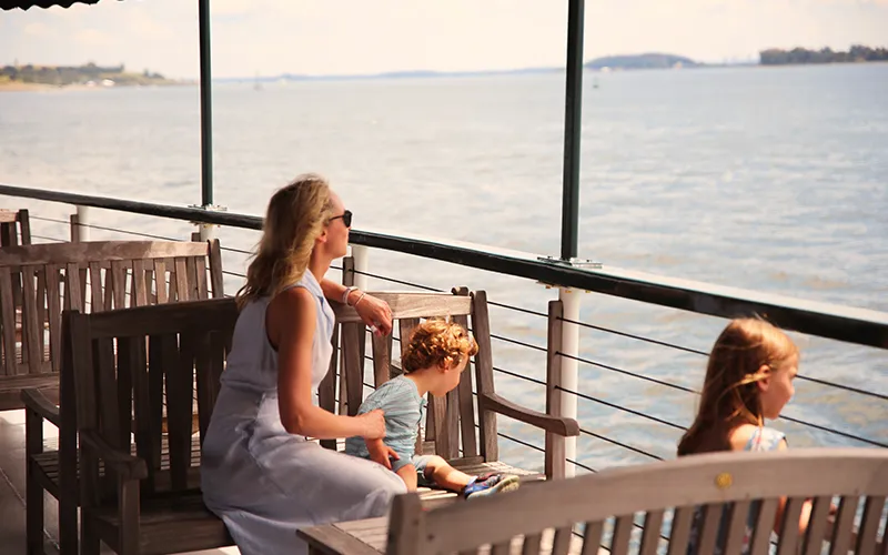 Mother and her children on a boat looking out at the sites