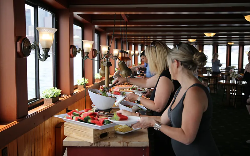 Guests getting food at a buffet in the grand salon of yacht Northern Lights