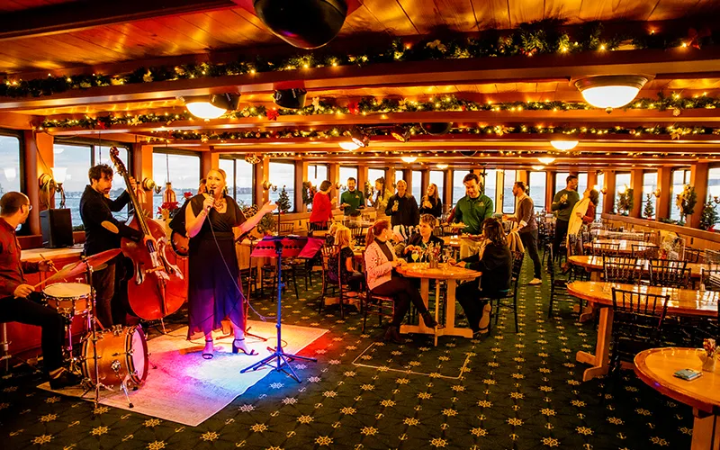 NLHoliday Grand Salon of the Yacht Northern Lights, decked out in holiday decor with guests and a live band