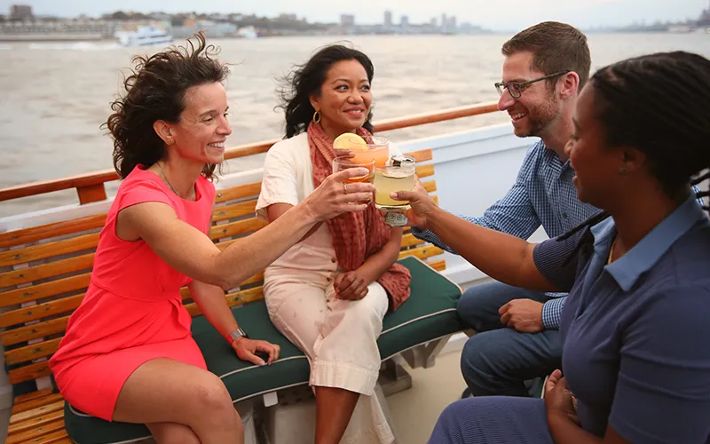 Patriotlifestyle41 Group of friends enjoying cocktails on the bow of the yacht Patriot in Boston Harbor for a sunset cruise