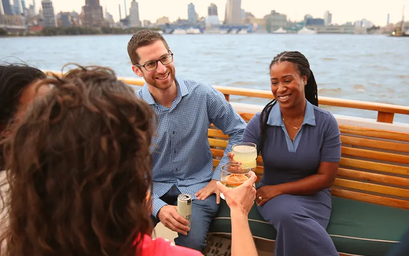 Guests on the bow of the yacht Patriot in Boston Harbor on a sightseeing cruise