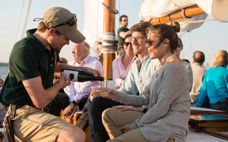 Guests being served champagne on the deck of a schooner